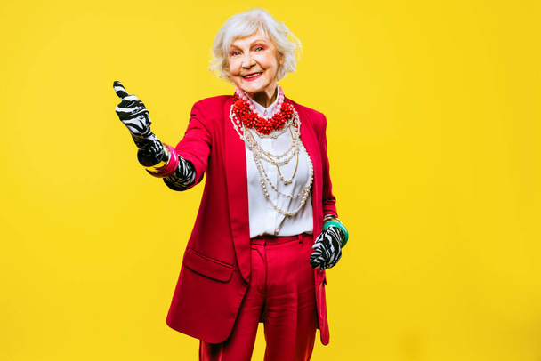 Šťastné a zábavné cool stará dáma s módní oblečení portrét na barevném pozadí - Mladistvý babička s extravagantní styl, pojmy o životním stylu, seniority a starší lidé - Fotografie, Obrázek