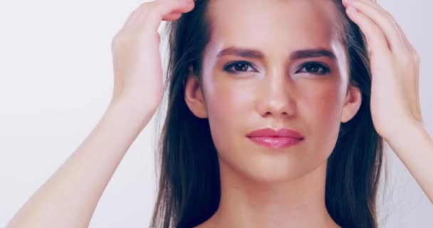 There is much to admire about her beautiful hair. 4k video footage of a beautiful young woman touching her gorgeous hair in the studio. - Imágenes, Vídeo