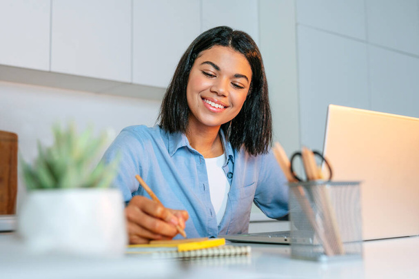Młoda kobieta biznesu pracuje przy laptopie siedząc przy biurku - Zdjęcie, obraz