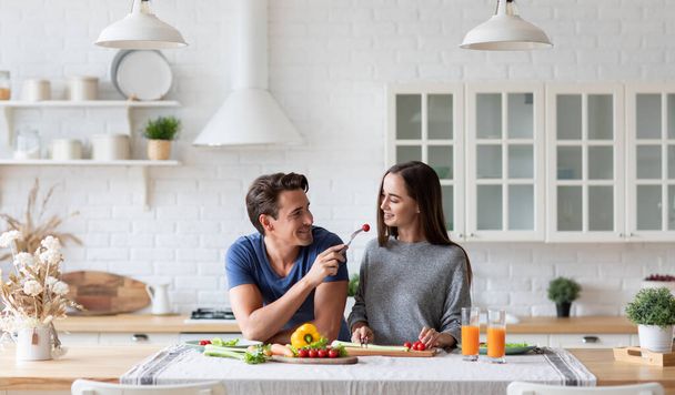 Young couple in the kitchen while preparing a vegetarian breakfast. Diet, healthy eating. - Foto, afbeelding