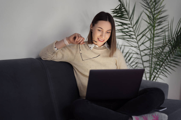Woman using laptop at home in the living room - Photo, Image
