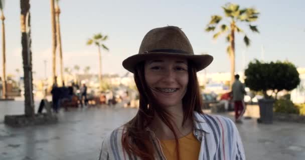 Uma jovem caucasiana feliz de chapéu, mostra e se alegra em um pacote de morangos frescos embalados. Close-up, verão, alegria, câmera lenta - Filmagem, Vídeo