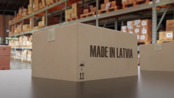 Krabičky s textem MADE IN LOTYŠSKO na dopravníku. Lotyšská smyčková 3D animace související se zbožím - Záběry, video