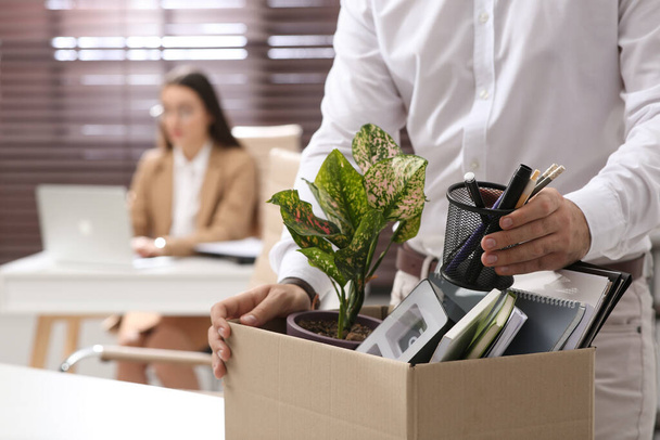 Dismissed man packing personal stuff into box in office, closeup - Foto, Imagen