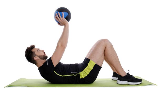 Атлетик делает упражнения с мячом, изолированным на белом - Фото, изображение