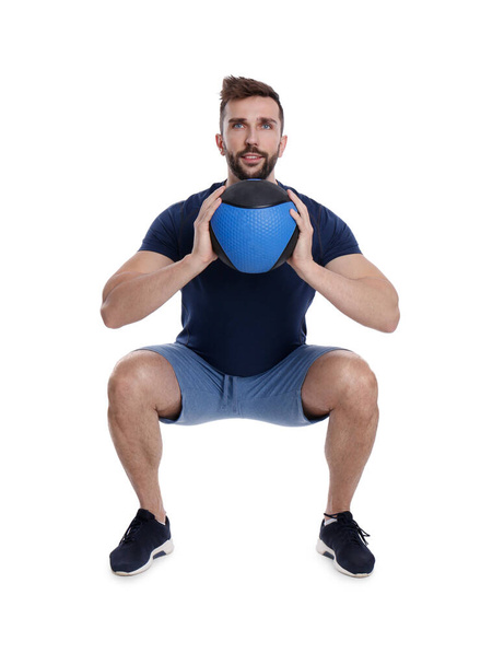 Athletic man doing squats with medicine ball isolated on white - Zdjęcie, obraz