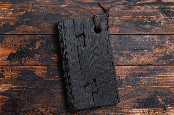Planche à découper en bois noir sur table de cuisine. Fond en bois. Vue de dessus. Espace de copie - Photo, image
