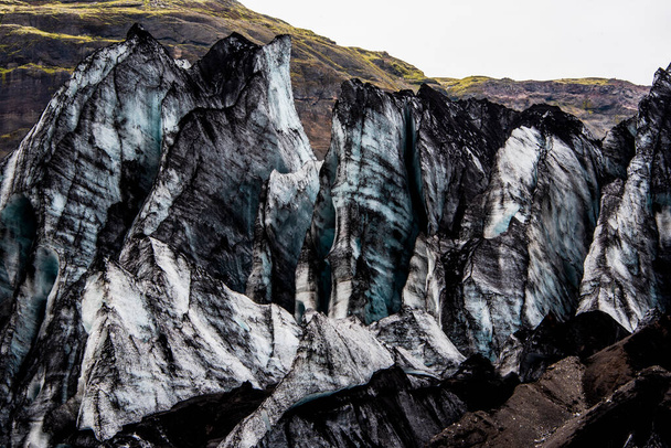 Solheimajokull-Gletscher von früheren Eruptionen mit Ruß bedeckt, wobei der Gletschersee vom Vulkan in der Nähe von Vik in Island herabsteigt - Foto, Bild