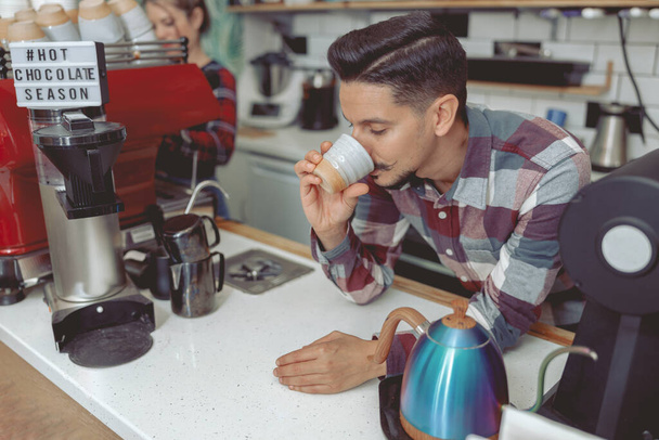 Молодий бариста в простій сорочці дегустація кави
 - Фото, зображення