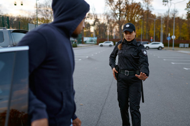 Oficial de policía tratando de hablar con ladrón de coches - Foto, imagen