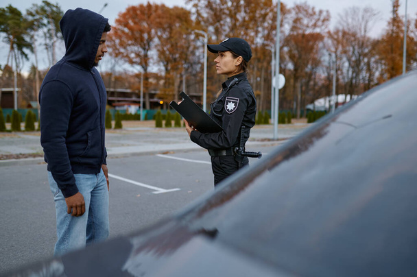 Женщина-офицер полиции назначает штраф правонарушителю - Фото, изображение