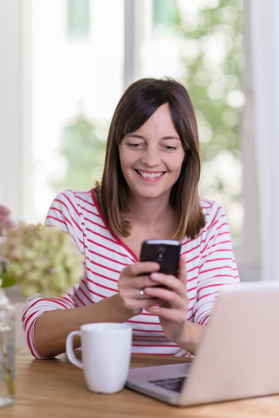Attractive woman smiling happily at an sms - Fotoğraf, Görsel