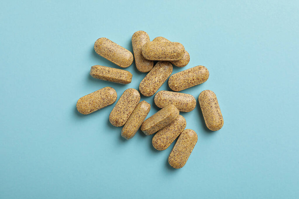 Dietary supplement pills on light blue background, flat lay - Фото, изображение