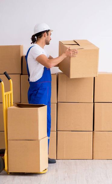 Jeune déménageur professionnel masculin faisant déménagement à la maison - Photo, image