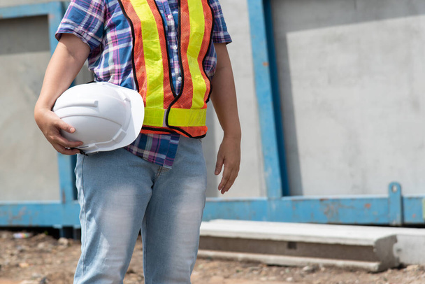 Азиатка, инженер-строитель или архитектор в шлеме и защитном жилете, счастлива работать на строительной площадке - Фото, изображение