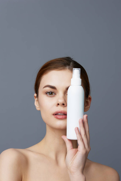 portret vrouw huidverzorging lotion met blote schouders geïsoleerde achtergrond - Foto, afbeelding