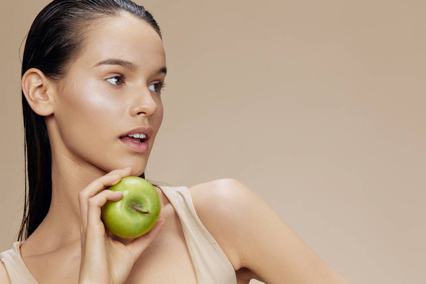ritratto donna mela verde vicino faccia salute beige sfondo - Foto, immagini