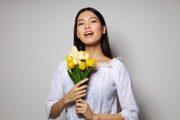 Portrait Asian beautiful young woman in a white shirt flowers spring posing light background unaltered - Valokuva, kuva