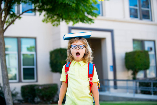 Il bambino sorridente felice con gli occhiali andrà a scuola per la prima volta. Gli alunni vanno a studiare. Il bambino con la borsa va alle elementari. Figlio della scuola elementare. Ritorno a scuola. - Foto, immagini