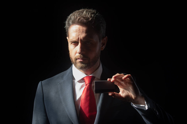 Portrait of a confident mature businessman in suit with credit card. - Fotoğraf, Görsel