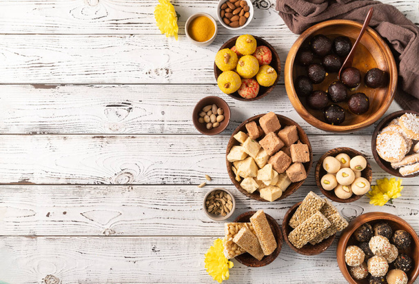 Indian traditional sweets laddu, gulab jamun, soan papdi, burfi for festival on rustic background with copy space, flat lay - Fotografie, Obrázek
