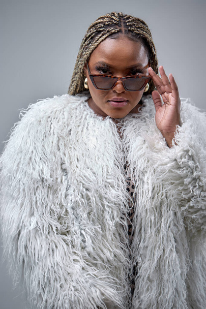 Plus size sexy model lady in fur coat with bright makeup, fashionable outfit, posing in studio - Foto, immagini