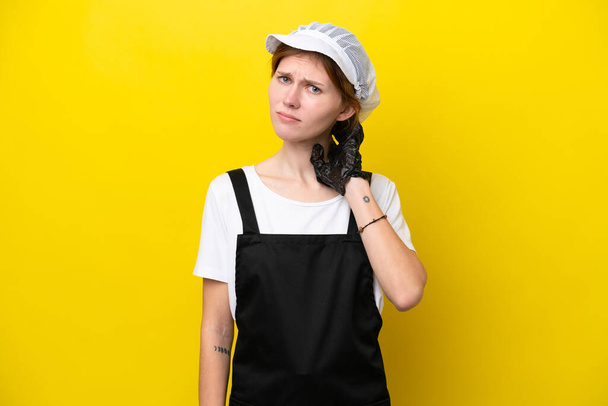 Young English fisherwoman isolated on yellow background having doubts - Fotografie, Obrázek