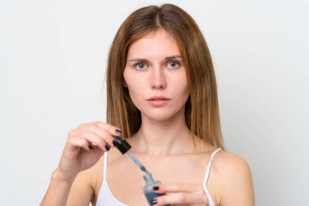 Young English woman holding a serum. Close up portrait - Фото, изображение