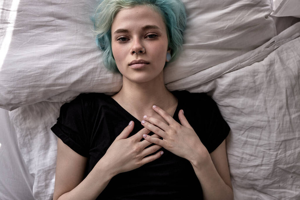 Unhappy exhausted woman lying on bed, suffering from headache or migraine - Фото, зображення
