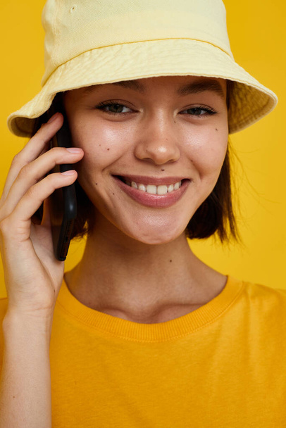 young woman in a yellow hat Youth style casual talking on the phone isolated background - Fotó, kép