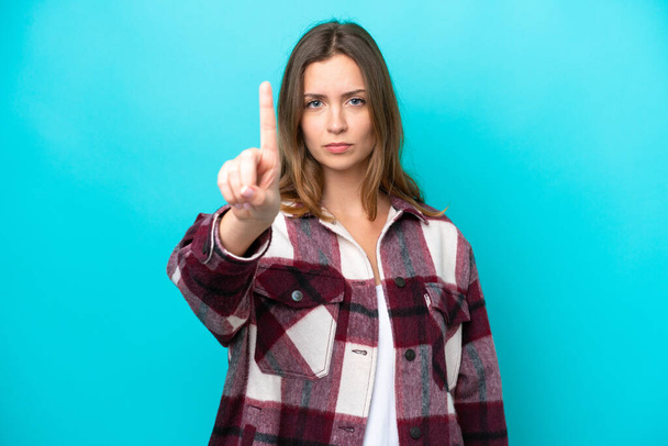 Young caucasian woman isolated on blue background counting one with serious expression - Foto, Imagen