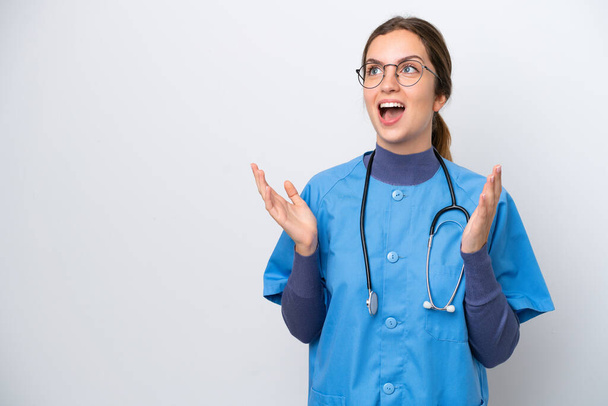 Giovane infermiera caucasica donna isolata su sfondo bianco con espressione facciale a sorpresa - Foto, immagini