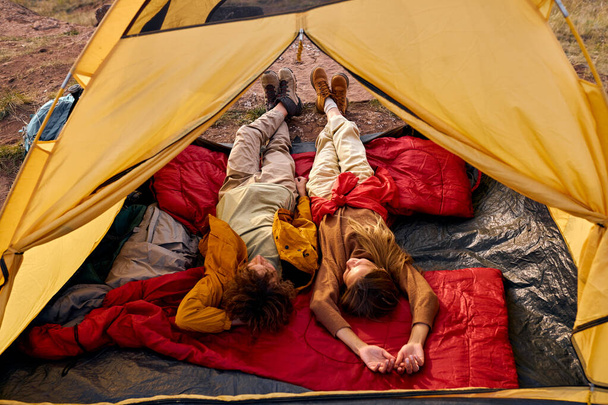 top view couple relaxing in camper tent and enjoying mountain autumnal lake views - Foto, Imagem