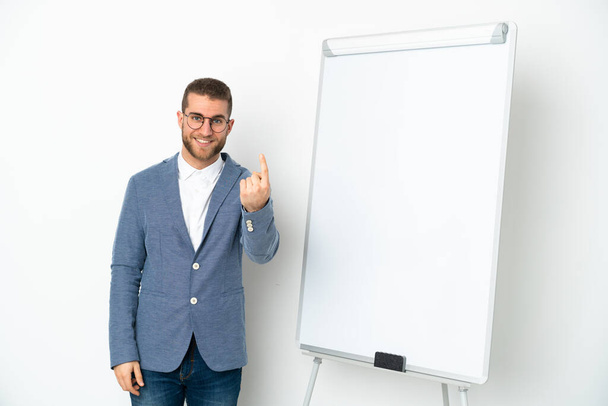 Jonge zakenvrouw het geven van een presentatie op witte boord geïsoleerd op witte achtergrond doen komende gebaar - Foto, afbeelding
