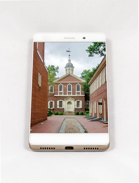 Moderní smartphone s celoobrazovkovým obrázkem Carpenterovy síně, Philadelphia, USA. Koncept pro cestování smartphone fotografie. Všechny obrázky v této kompozici vytvořené mnou, samostatně dostupné na mém portfoliu - Fotografie, Obrázek