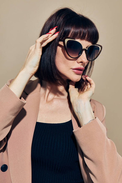 photo pretty woman in a beige jacket elegant style sunglasses Lifestyle unaltered - Foto, afbeelding