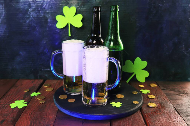 パトリックの日、ガラスのマグカップやボトル、チップ、黄金のコインや木製の背景に緑のシャムロックで泡立つビール、パーティー、お祝い、ポストカード - 写真・画像
