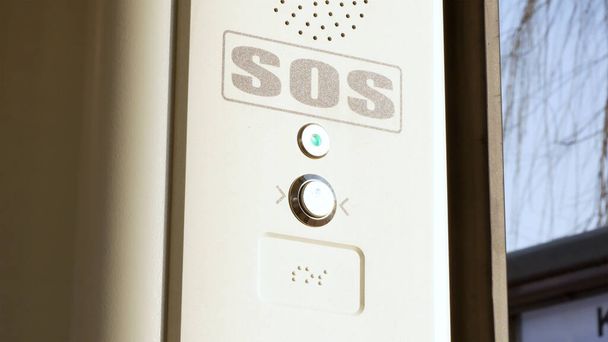 SOS jelzőgomb a villamos belsejében, vonat, segélyhívó rendszer nyomógomb, Braille felirat, részletek, közelkép Tömegközlekedés biztonsága, városi közlekedés biztonsága, megközelíthetőség absztrakt koncepció - Fotó, kép