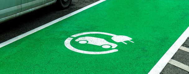 空の電気自動車充電ステーション駐車場、マーク緑のゾーン、アスファルト上の車の充電デバイスのシンボルは、誰も。環境に優しい車、交通手段、交通手段 - 写真・画像