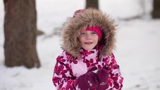 Dziewczyna uśmiecha się zimą i spędza dobry dzień, portret - Materiał filmowy, wideo