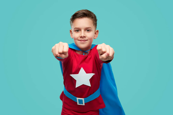 Content superhero child showing fists to camera - Foto, Imagen