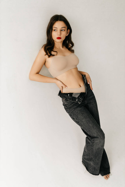 Dívka modelka brunetka v béžové top na bílém pozadí - Fotografie, Obrázek