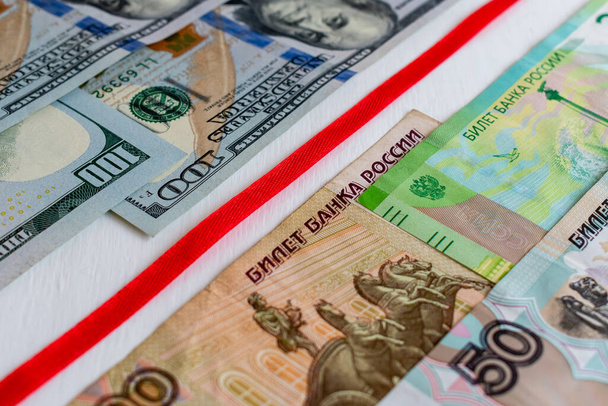 Rotes Band trennt US-Dollarnoten von russischen Rubel - Foto, Bild