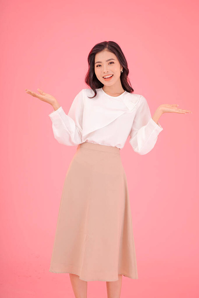 Asian attractive beautiful young woman with hand gesture, showing with finger on the copy space, isolated on background - Fotoğraf, Görsel