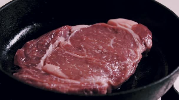 Cottura bistecca ribeye in una padella di ghisa - Filmati, video
