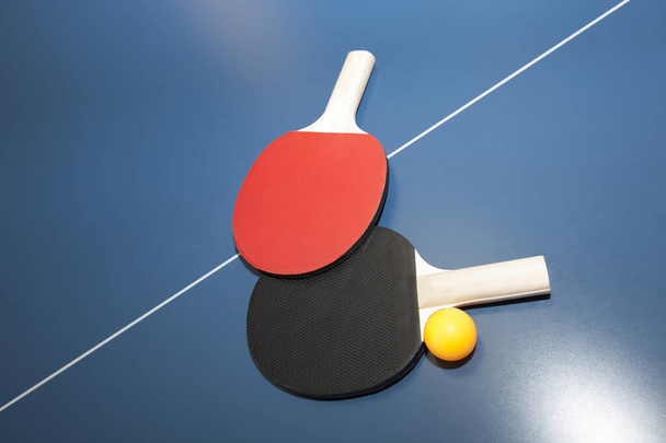 Table de ping-pong, deux pagaies et des balles dans une salle de gym sur une table. - Photo, image
