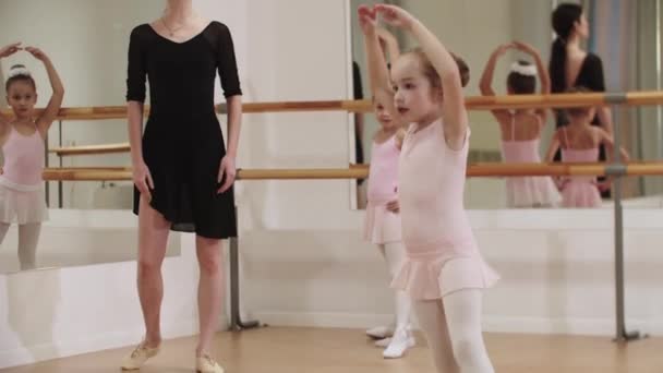 Tres niñas de ballet entrenando con su entrenador femenino en el estudio del espejo - Imágenes, Vídeo