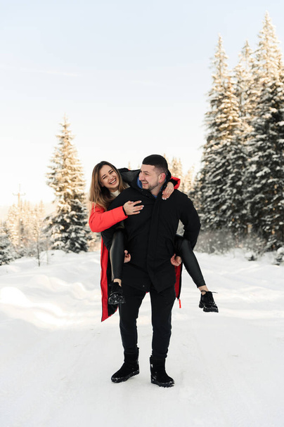 love and vacation concept - happy couple hugging and laughing outdoors in winter.couple in nature - Fotografie, Obrázek