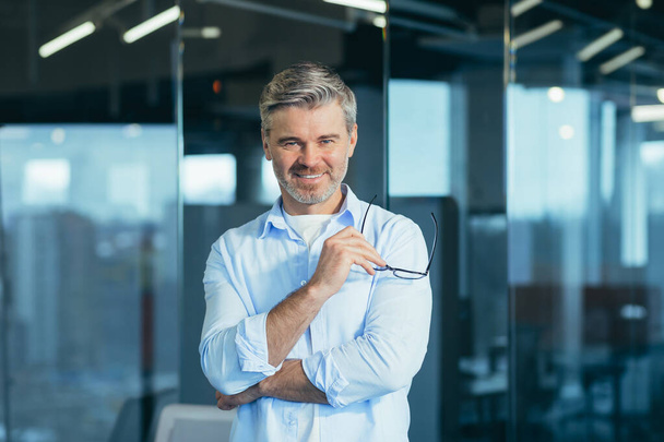 Happy bearded businessman entrepreneur startup owner standing in modern office looking at camera, smiling young hipster, creative man posing in workspace, business portrait - Zdjęcie, obraz