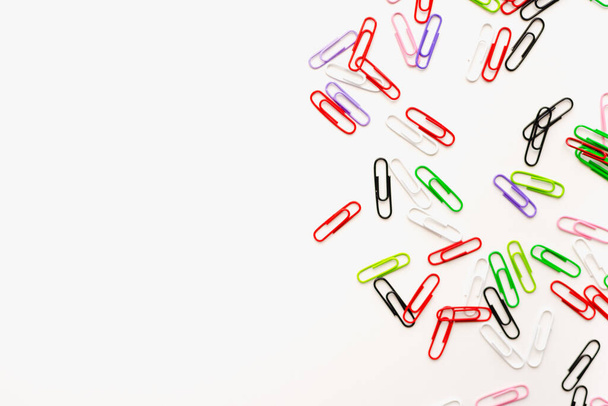Colored paper clips on a white background. Stationery.  - Foto, imagen